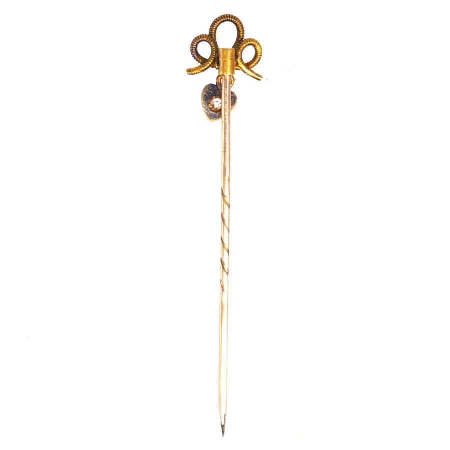 Edwardian 15ct gold knot tie pin with dangling diamond heart, symbolizing timeless love and elegance.