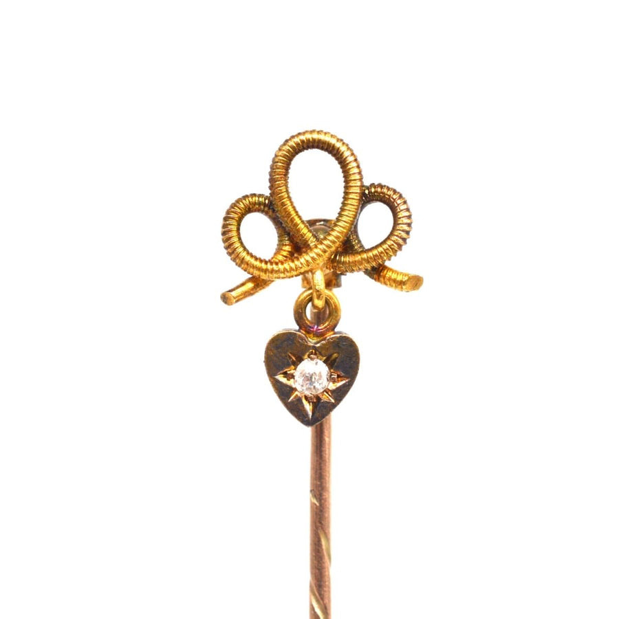 Edwardian 15ct gold knot tie pin featuring a dangling diamond heart, symbolizing eternal love and romance.