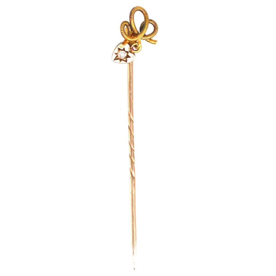 Edwardian 15ct gold knot tie pin with a dangling diamond heart, symbolizing eternal love and romance.