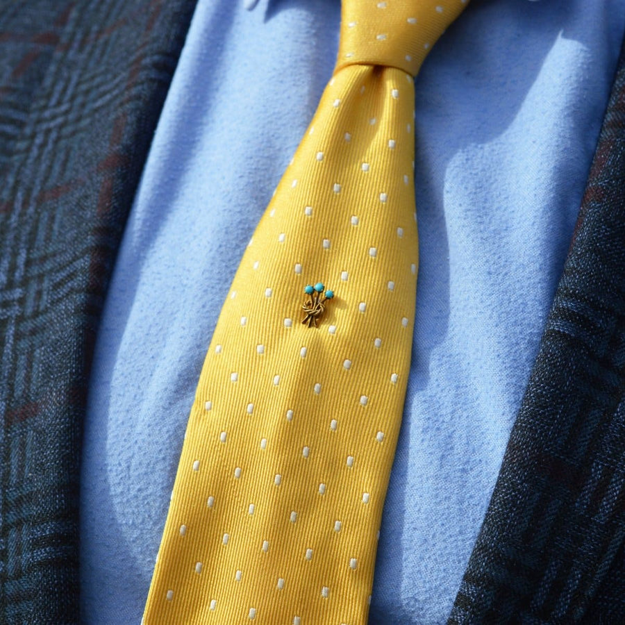 Edwardian 15ct gold tie pin with trio of turquoise stones on a yellow polka dot tie.