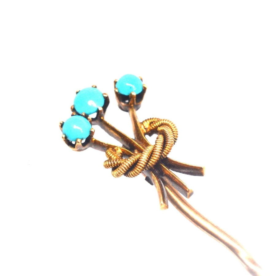 Edwardian 15ct gold tie pin featuring three turquoise stones in a floral knot design, evoking elegance and December's birthstone.
