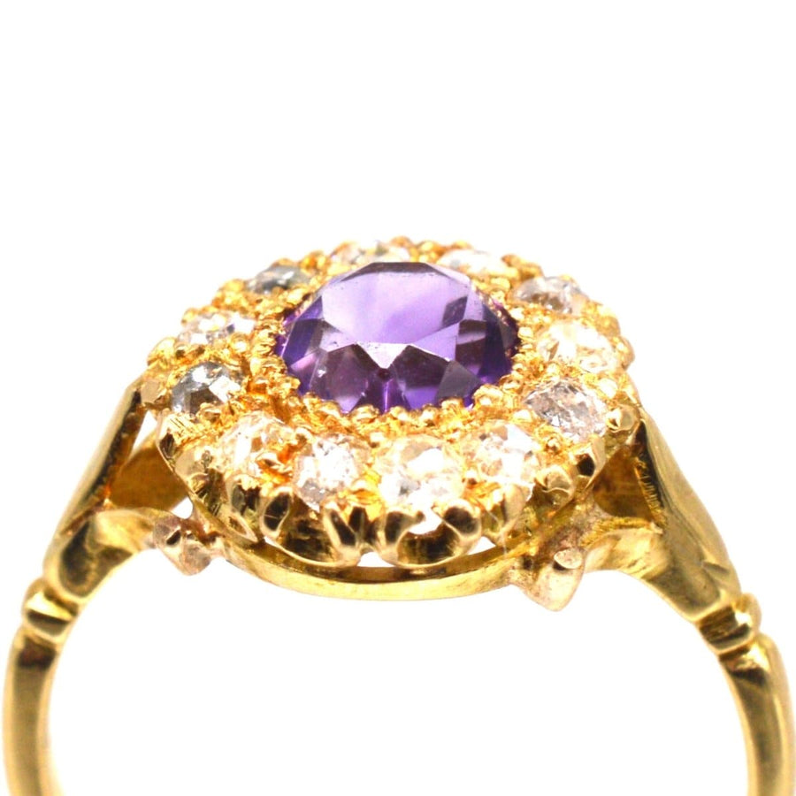 Edwardian 18ct gold ring with amethyst center and diamond cluster accents.