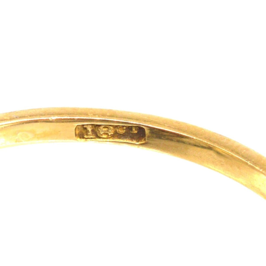 Close-up of the inside hallmark of an Edwardian 18ct gold and platinum five stone diamond ring.