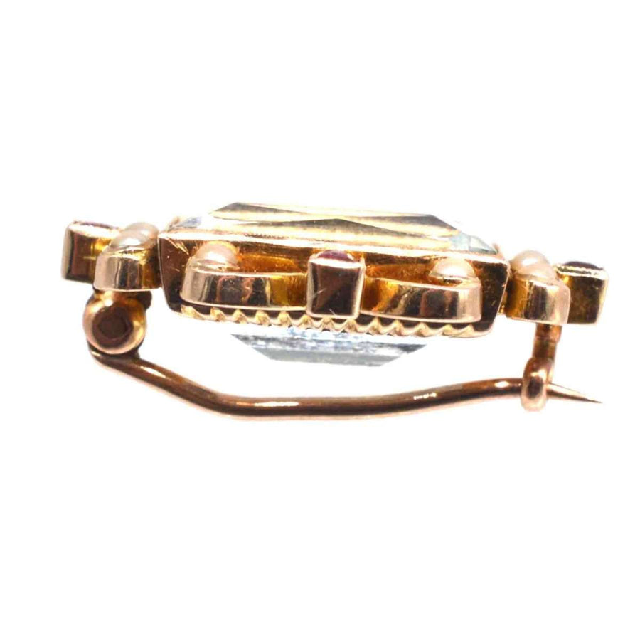 Side view of Edwardian 18ct gold brooch featuring a large aquamarine, surrounded by pearls and rubies.