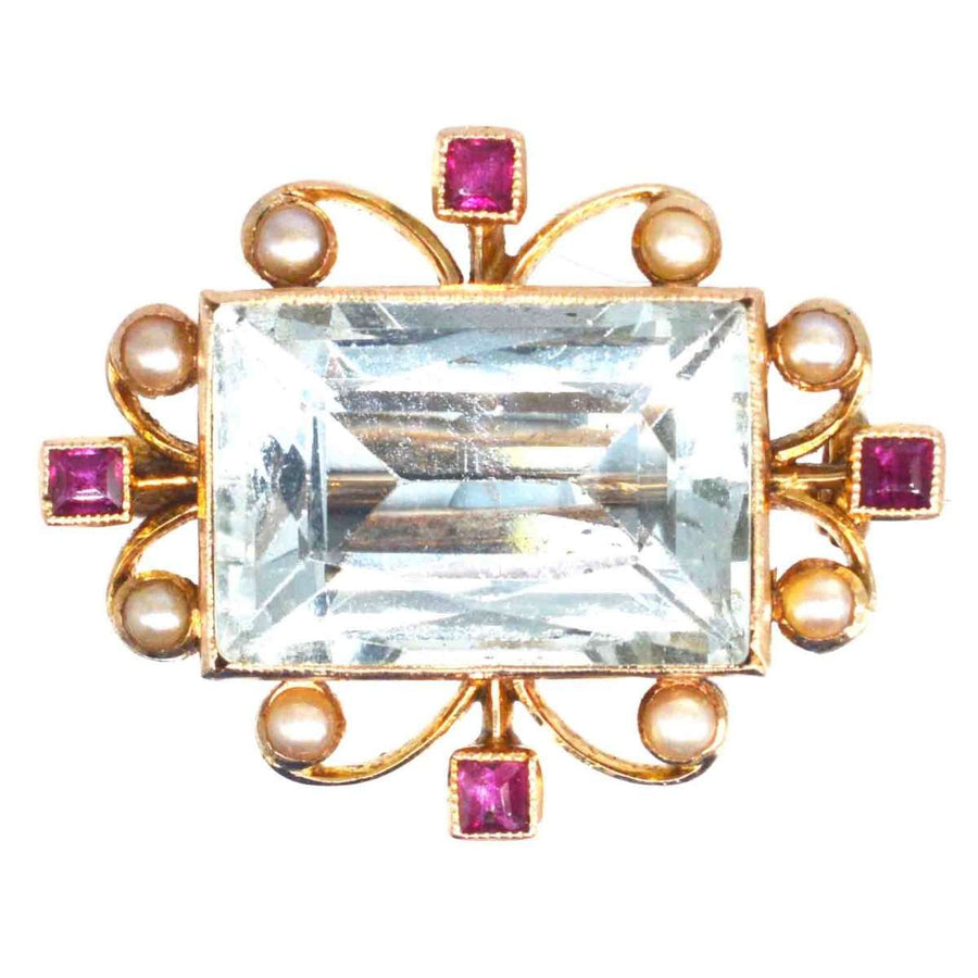 Edwardian 18ct gold brooch featuring large aquamarine, ruby accents, and pearl embellishments.