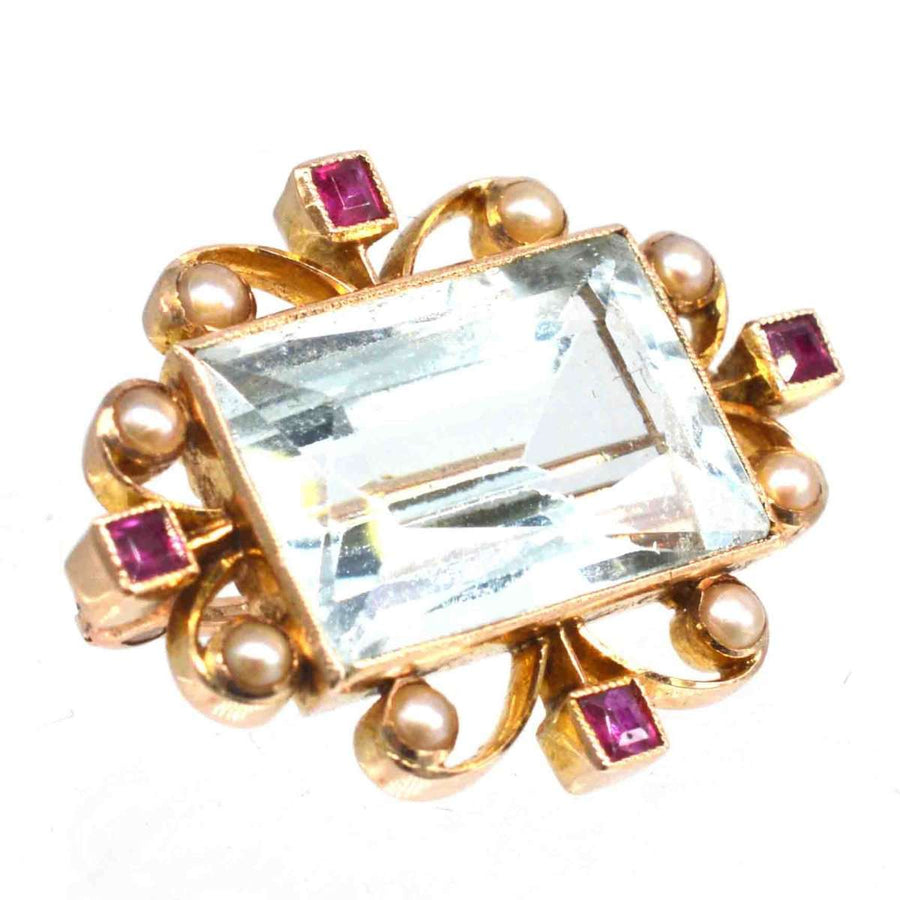 Edwardian 18ct gold brooch featuring aquamarine, ruby accents, and pearls in a stunning design.
