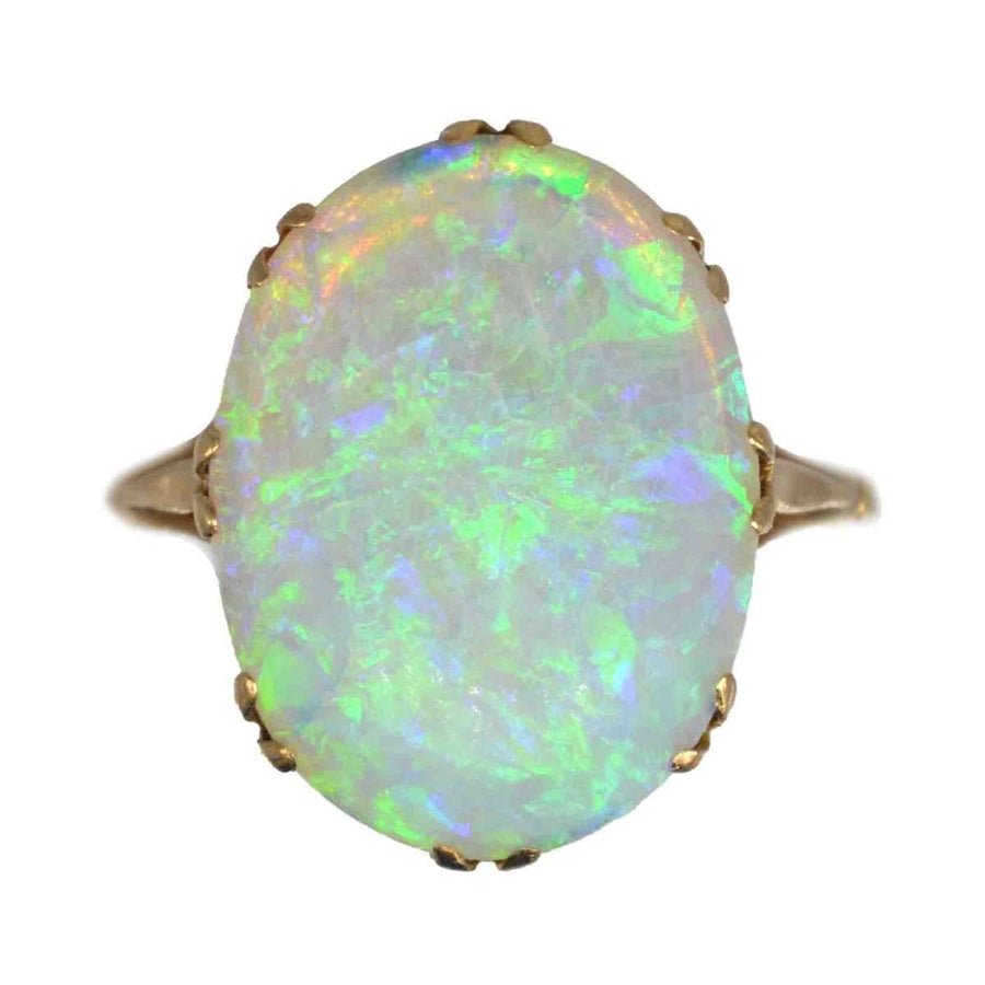 Edwardian 18ct gold ring featuring a large, lustrous opal with vibrant green and blue flashes of color.