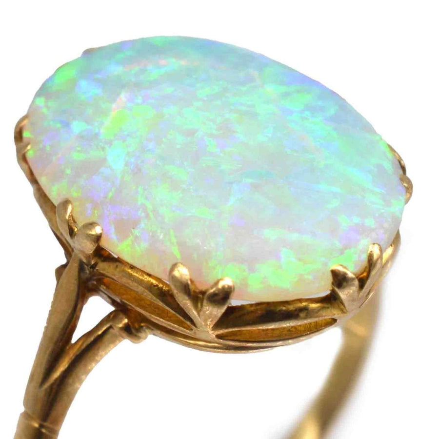 Edwardian 18ct gold ring featuring a large, colorful opal with vivid flashes of green and blue.
