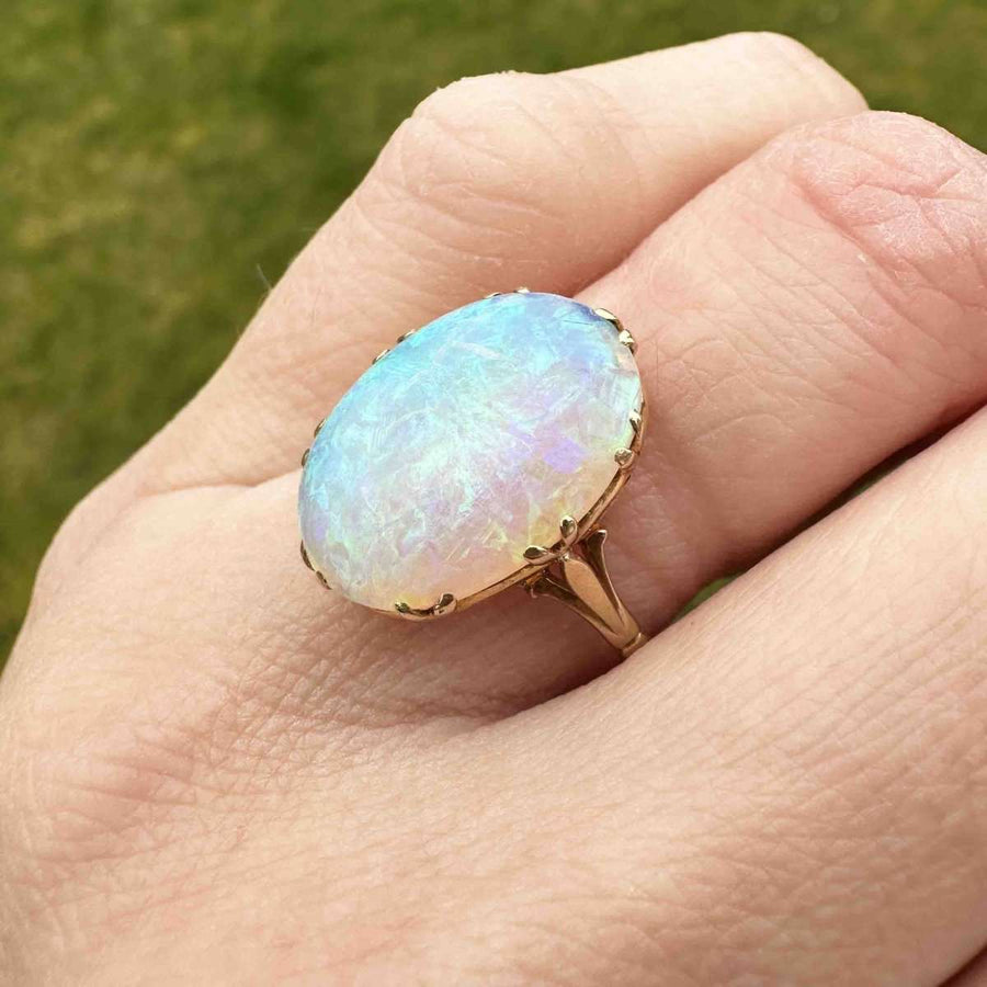 Edwardian 18ct gold large opal ring, showcasing vivid flashes of color, worn on a hand in natural light.
