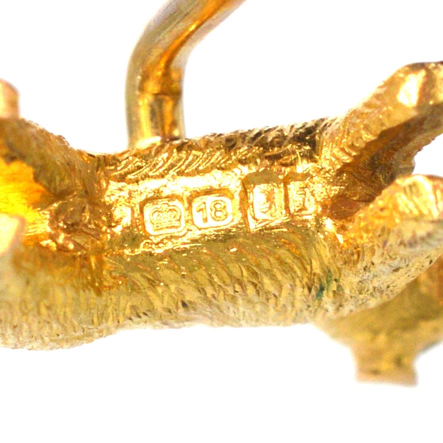 Close-up of an Edwardian 18ct gold terrier dog tie pin, showcasing detailed craftsmanship and hallmarking.