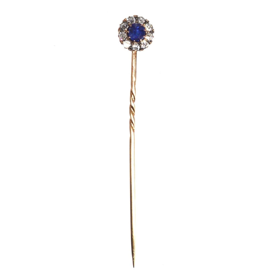Edwardian 18ct rose gold sapphire and diamond cluster tie pin featuring a central blue sapphire.