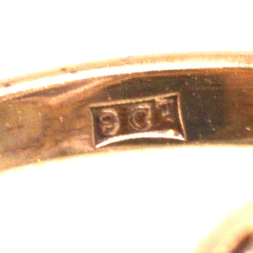 Close-up of the inner band marking of a 9ct gold ring, showcasing authenticity stamp.