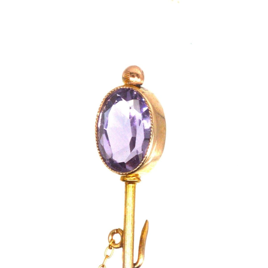 Close-up of Edwardian 9ct gold tie pin featuring an oval purple amethyst and a chain with freshwater pearls.