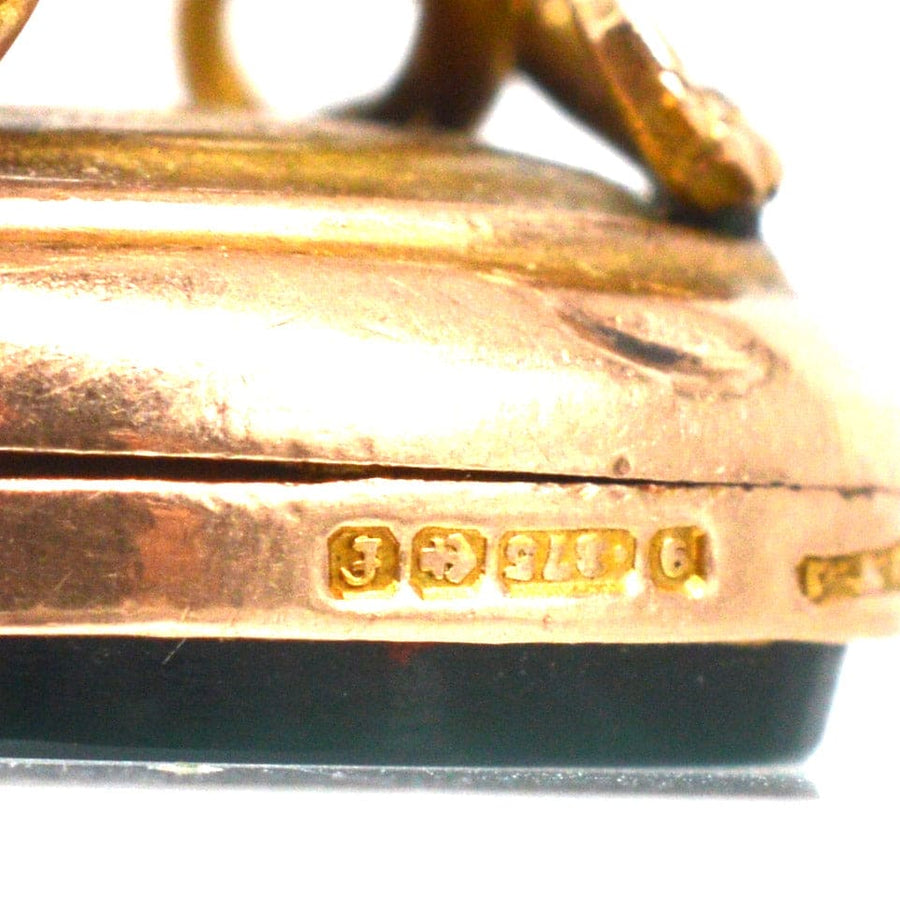 Close-up of Edwardian 9ct gold pendant showing hallmark and intricate design details on the base.