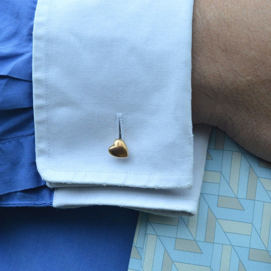 Close-up of a man's cuff with a 9ct gold puffy heart cufflink, perfect for expressing love.