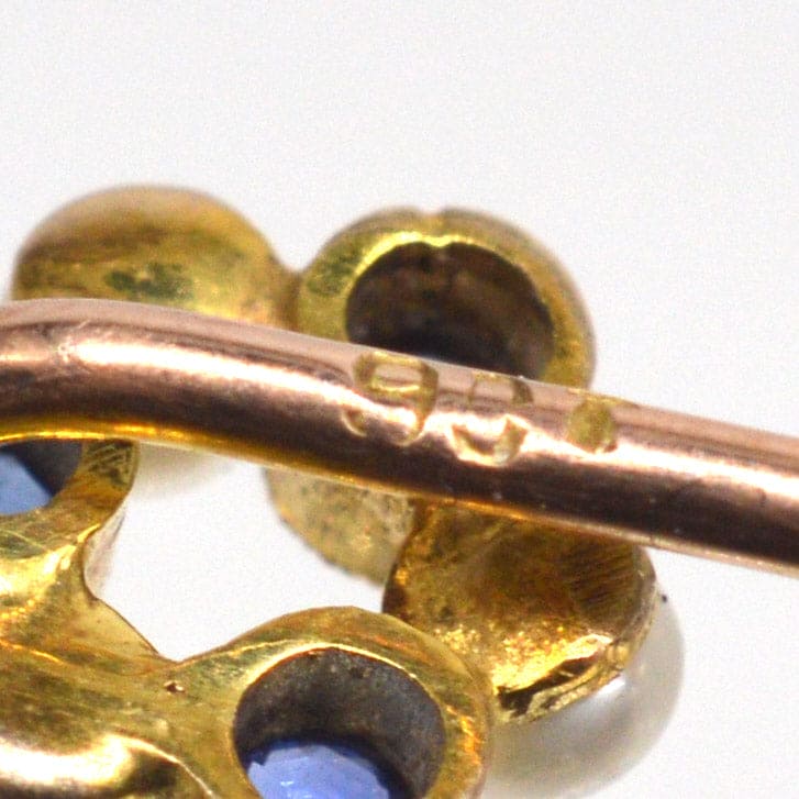 Close-up of the Edwardian 9ct gold tie pin showcasing sapphire and pearl details, circa 1910s.