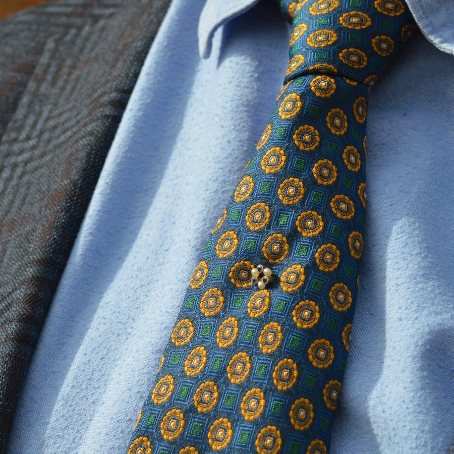 Edwardian 9ct gold sapphire and pearl wreath tie pin on a patterned blue tie.