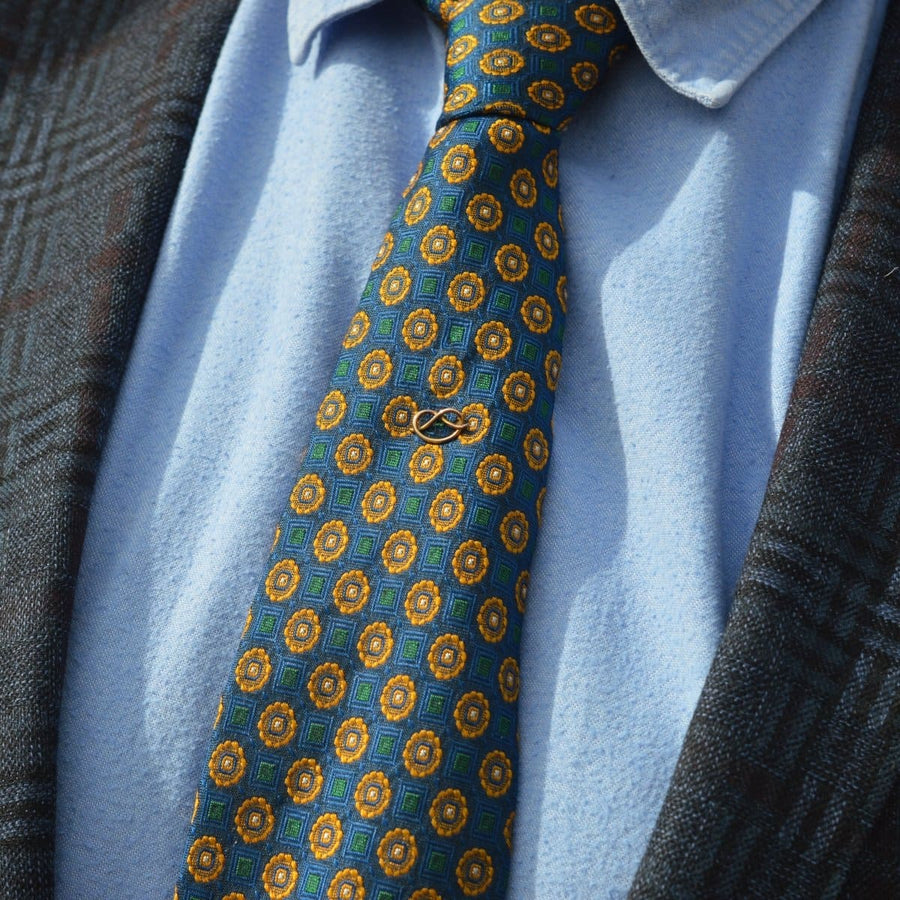 Edwardian 9ct gold Stafford Knot tie pin on patterned tie, showcasing a vintage, sophisticated look.