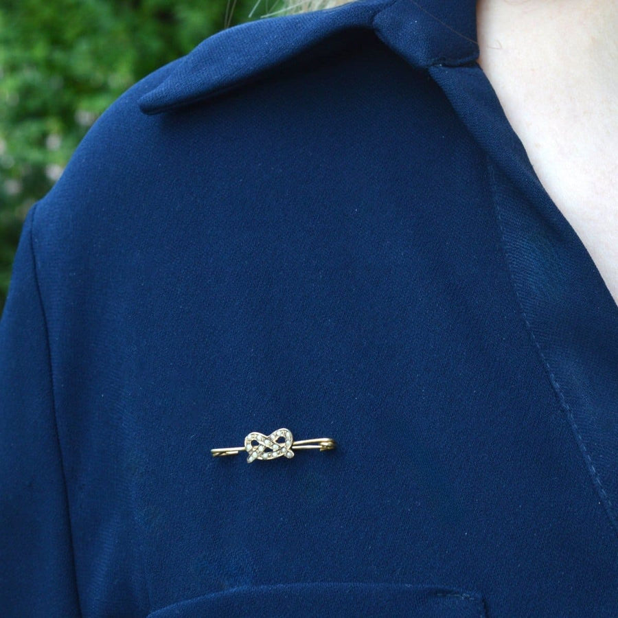 Elegant 9ct gold Stafford Knot brooch with natural split pearls, worn on a navy jacket.