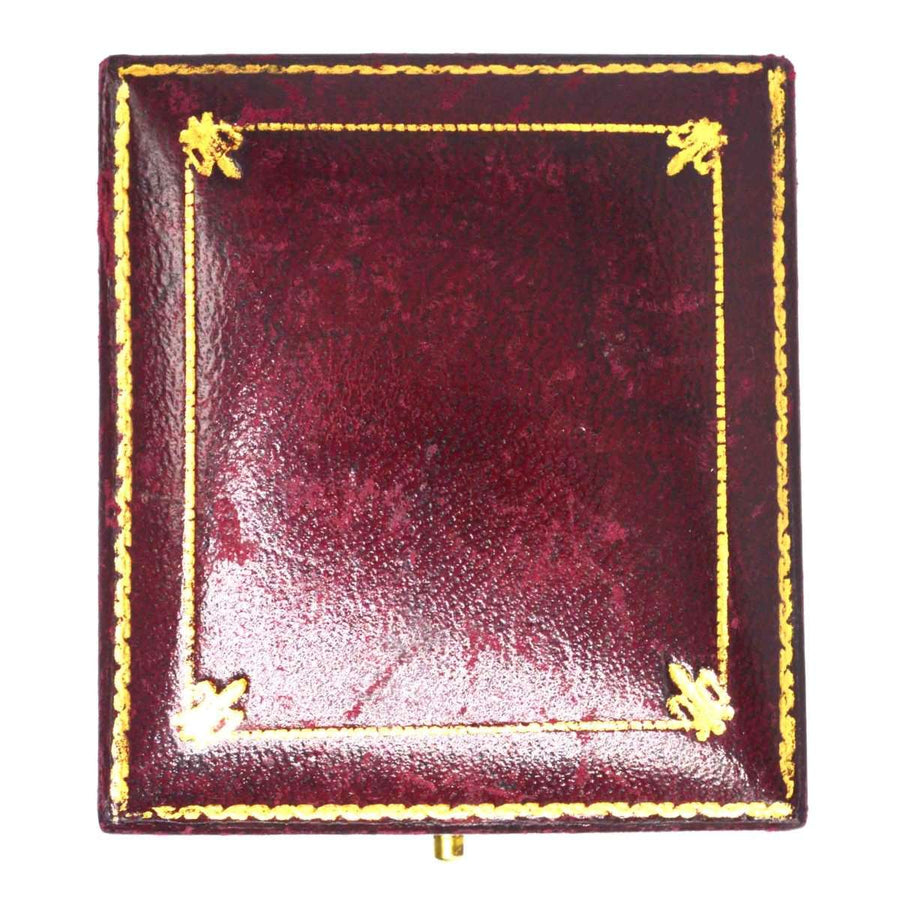 Rich burgundy jewelry box with gold detailing and ornate corners, perfect for storing precious items.