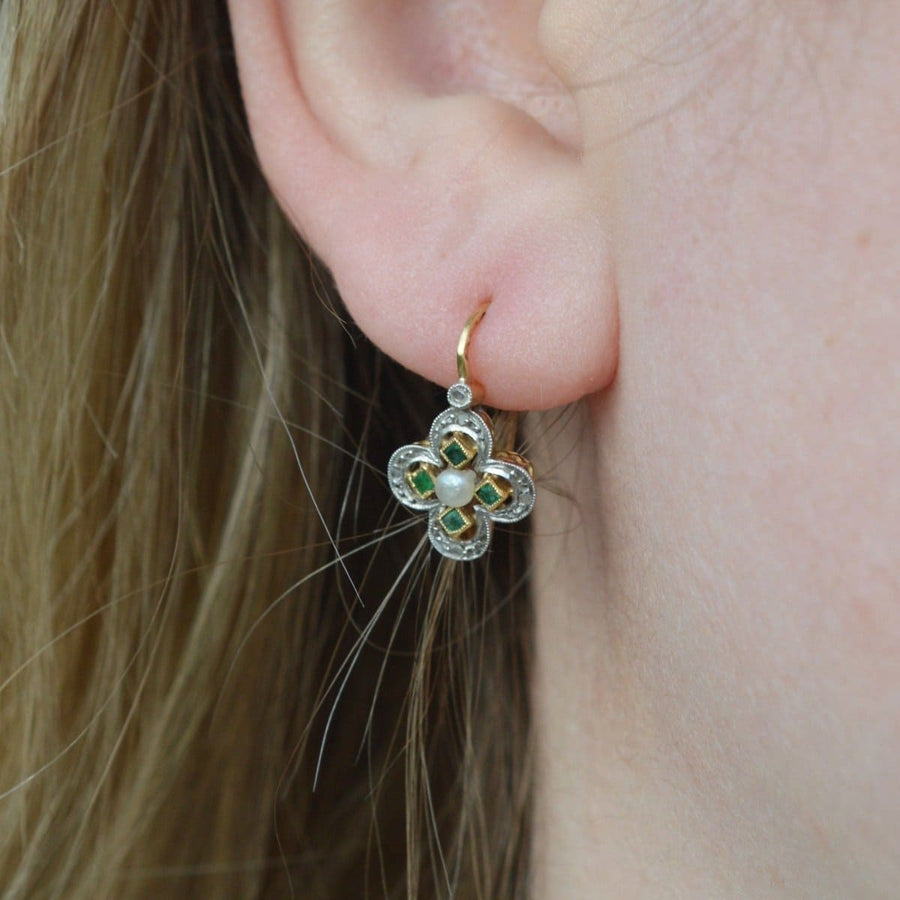 Elegant Edwardian quatrefoil earrings featuring diamonds, a square emerald, and a natural pearl, perfect for any occasion.