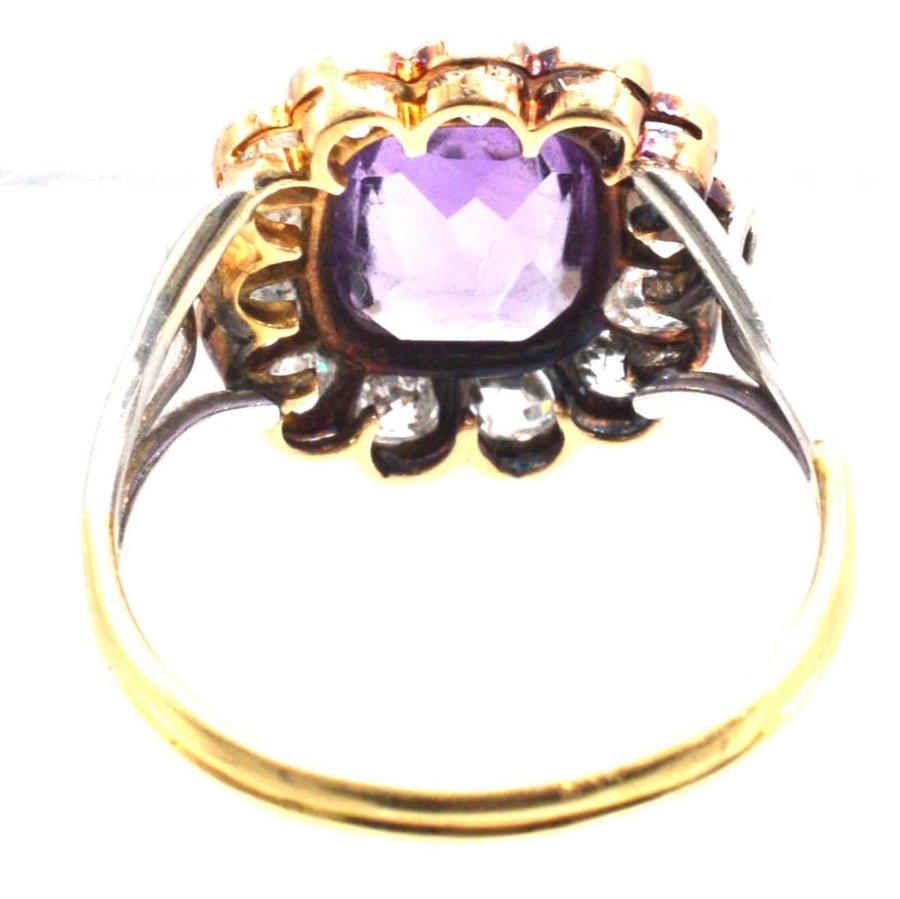 Edwardian platinum and gold ring featuring an amethyst and diamond cluster, showcasing unique triple loop design.