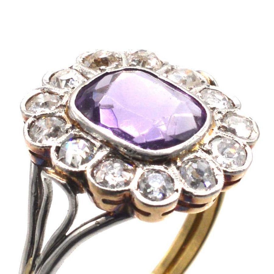 Edwardian platinum and gold amethyst cluster ring with old cut diamonds, featuring unique triple loop shoulders.