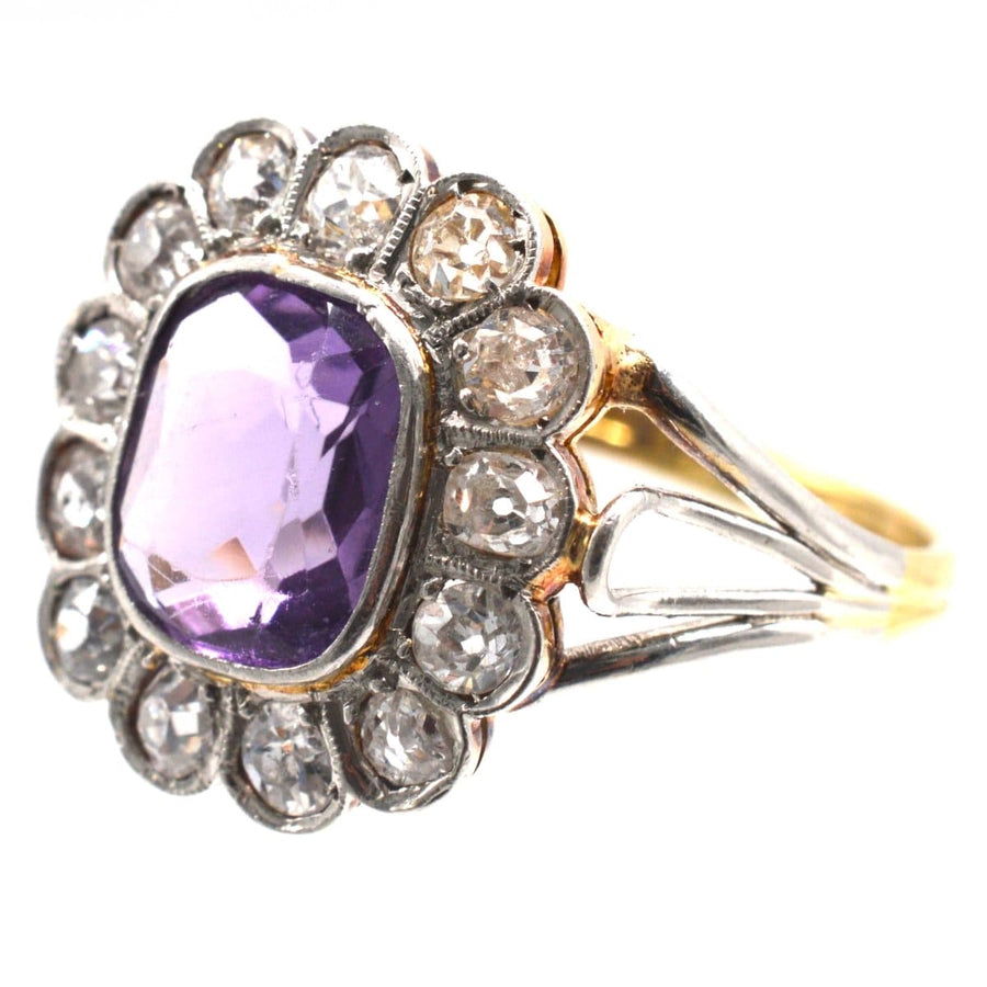 Edwardian platinum and gold ring with amethyst and diamond cluster design, featuring unique triple loop shoulders.