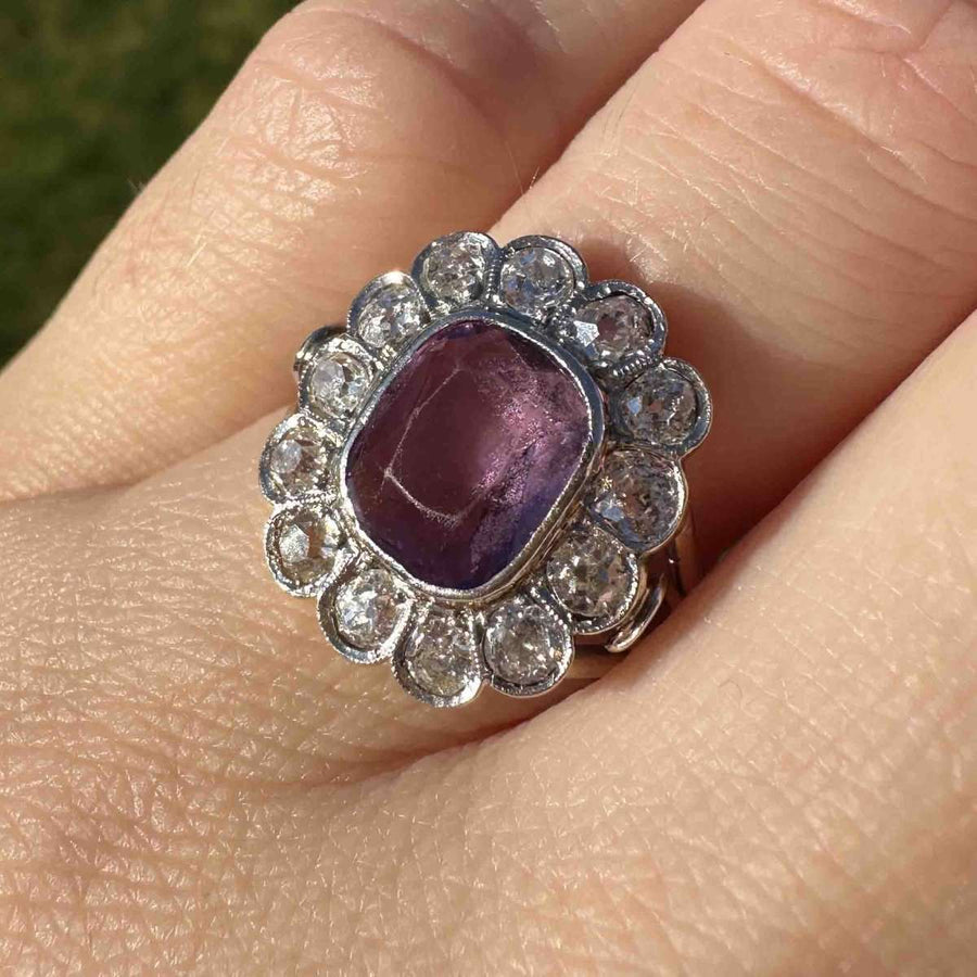 Edwardian platinum and gold amethyst ring with diamond cluster, showcasing vintage style and elegance.