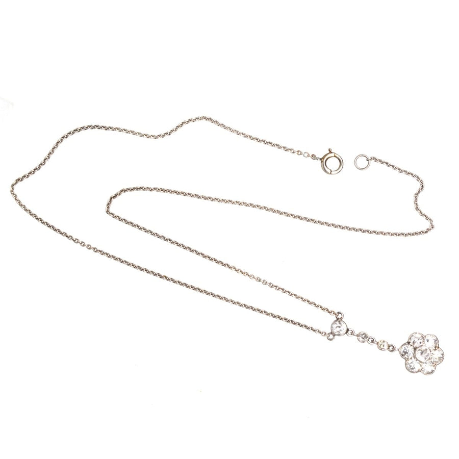 Edwardian platinum diamond cluster drop necklace featuring a floral design with three diamonds and elegant chain.