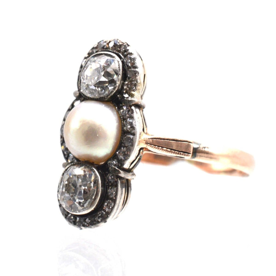 Edwardian silver and 15ct gold ring with two diamonds and a natural pearl centerpiece, circa 1905.