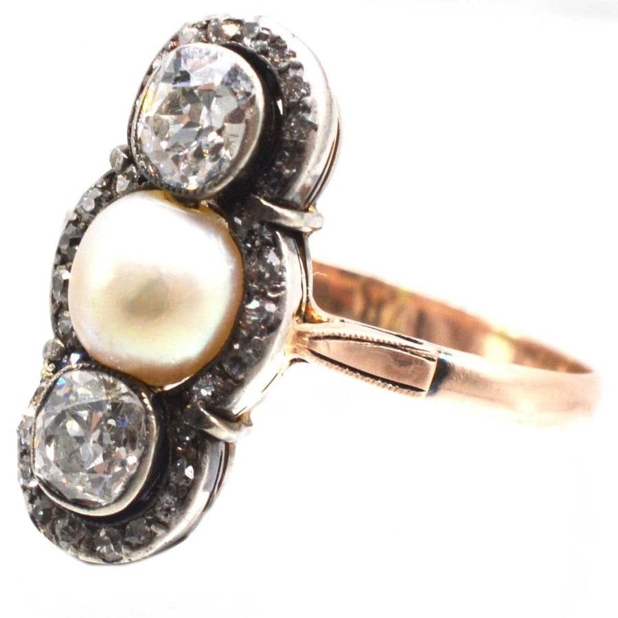 Edwardian 15ct gold ring featuring two old mine cut diamonds and a central natural pearl, circa 1905.