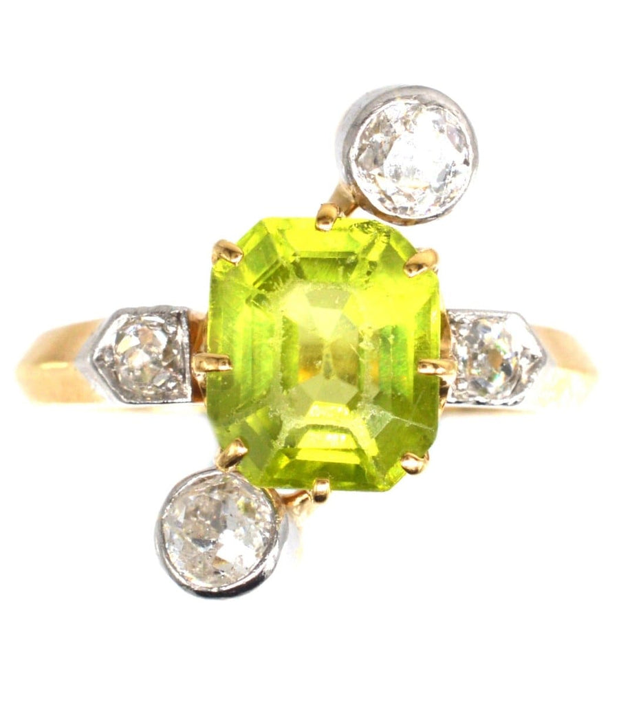 Belle Epoque peridot and diamond ring with an asymmetrical design, featuring a vibrant peridot centerpiece and diamonds.