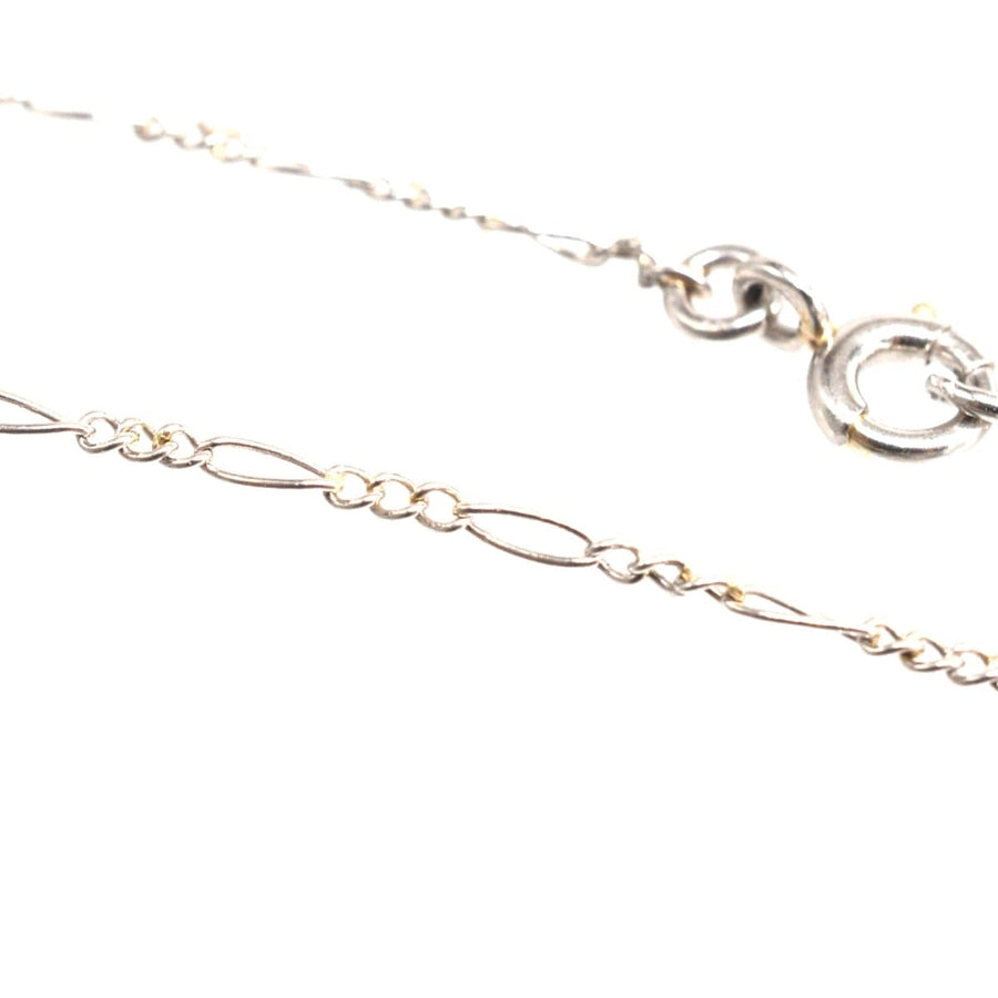 Close-up of a delicate silver chain with unique interlocking links and a secure clasp.