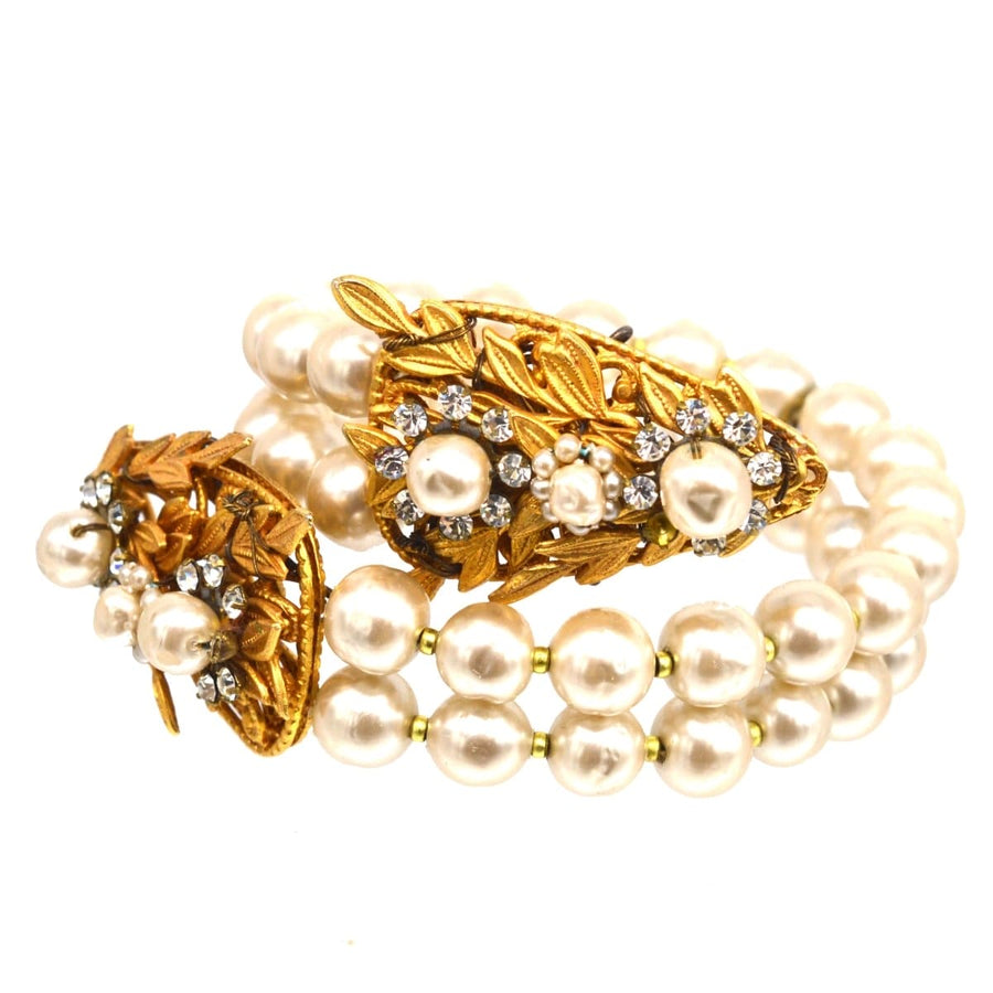 Miriam Haskell white paste and faux pearl open bangle featuring a gold serpent design and lustrous faux pearls.