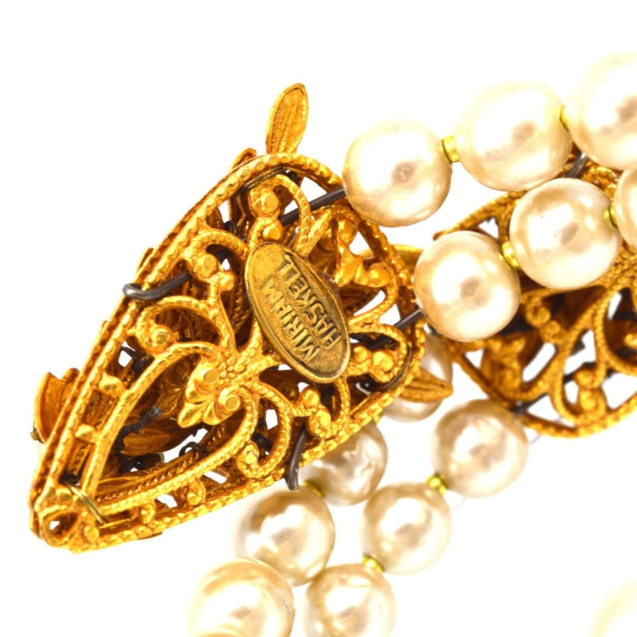 Miriam Haskell gold metal serpent bangle with white paste and faux pearl clusters detail.