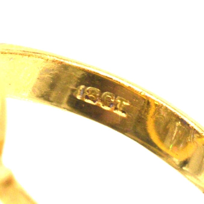 Close-up of hallmark engraving with the number 18CT on the inside of a ring band.