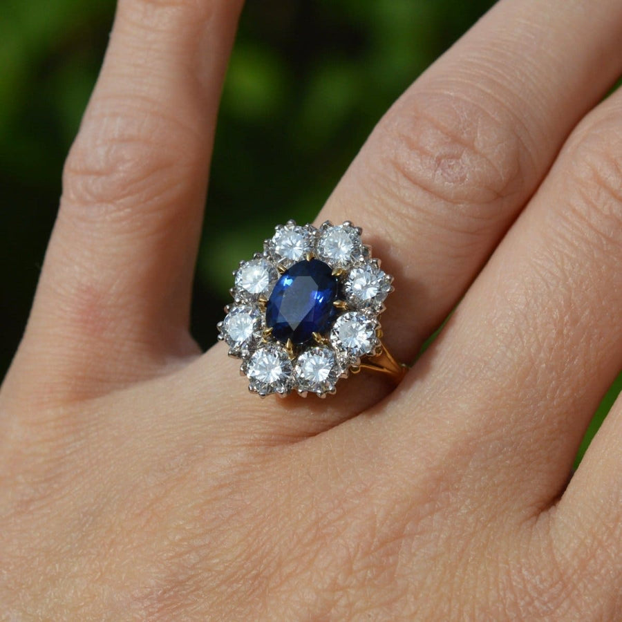 Large mid-century sapphire and diamond cluster ring featuring a central sapphire surrounded by brilliant diamonds.
