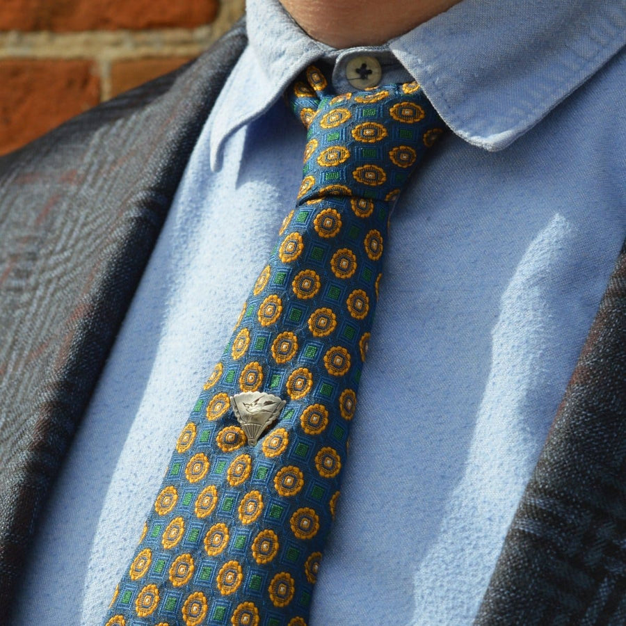 Late 19th century Aesthetic period bird tie pin on a colorful patterned tie, showcasing vintage elegance.