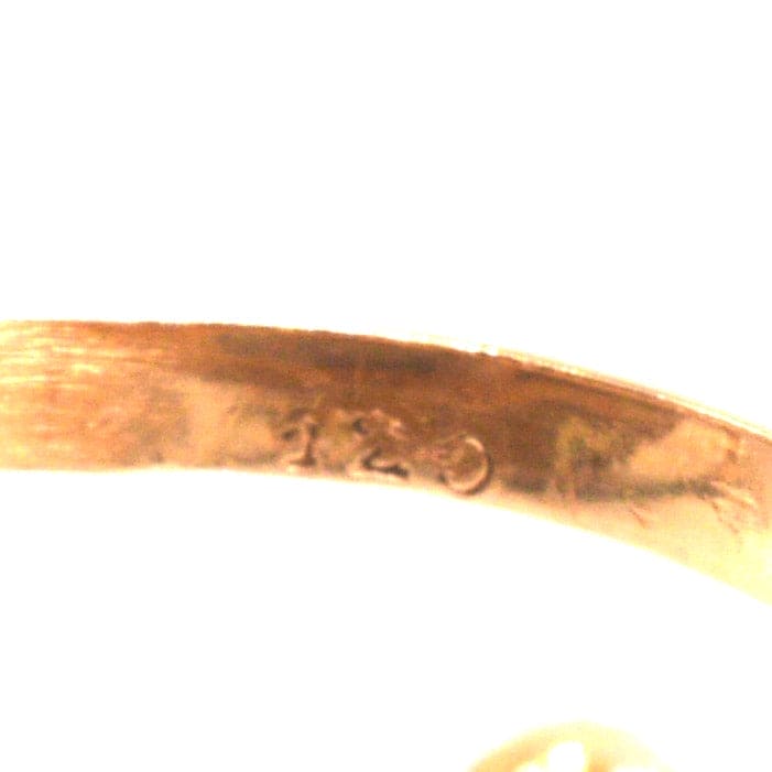 Close-up of the inside hallmarks of a 18ct gold antique ring, showing quality stamp and fine detailing.