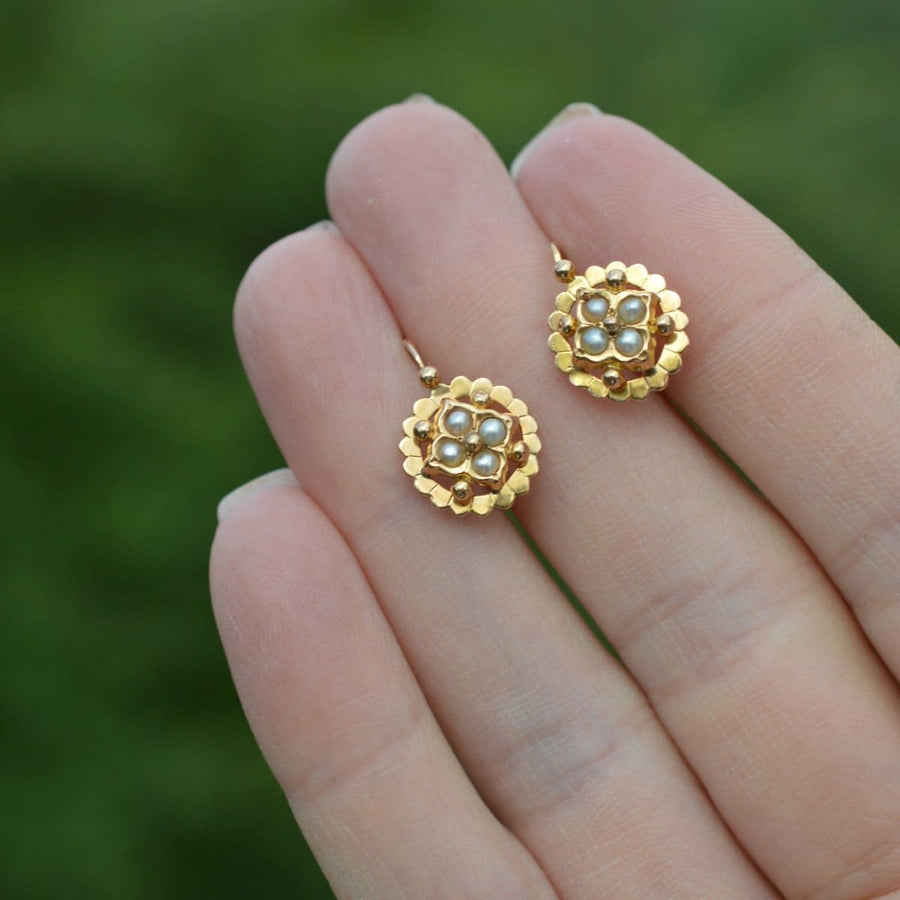 Late 19th Century French gold dormeuses earrings with split pearls, crafted in 1880s, held in hand.