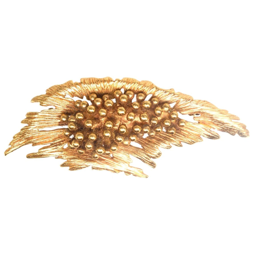 Mid-century modernist gold spray brooch featuring naturalistic floral design with bold textures and details.