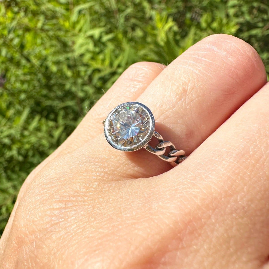 Modern 18ct white gold ring featuring a 1.8 carat round brilliant diamond in a unique curb chain setting.