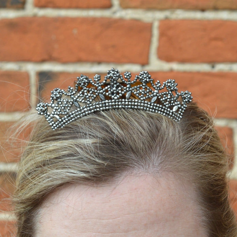 Regency Early 19th Century Cut Steel Tiara Hair Comb showcased on a model's hair against a brick background.