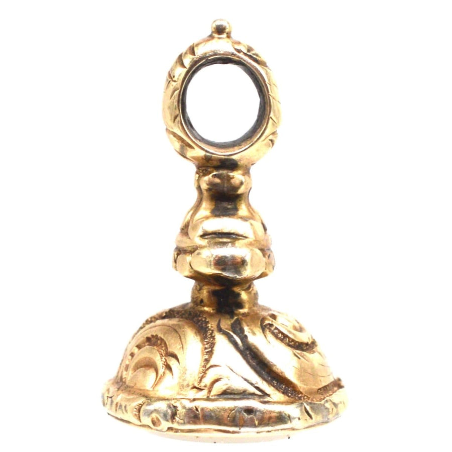 Regency gold cased small seal charm featuring detailed repousse work and chalcedony stone base from the 1820s.