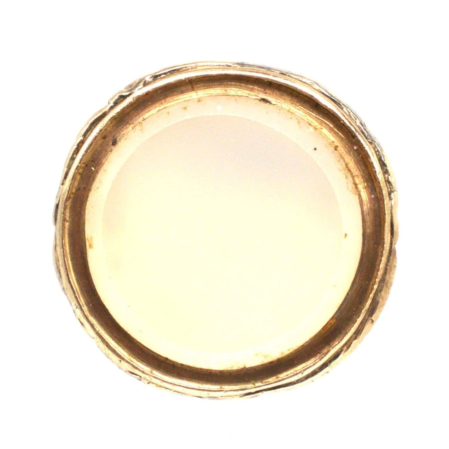 Regency gold cased small seal charm featuring a smooth chalcedony base, showcasing intricate repousse details.
