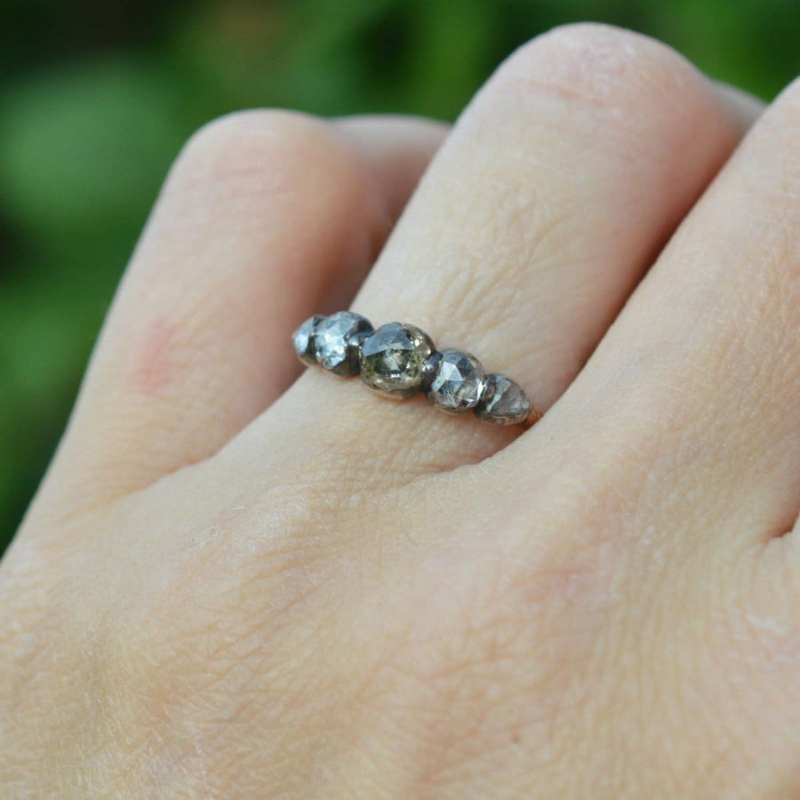 Regency silver and gold five stone rose cut diamond ring elegantly worn on a hand.