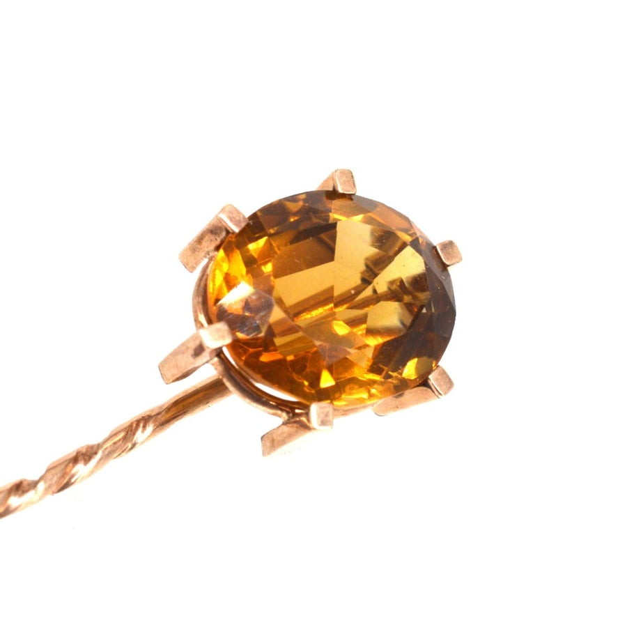 Close-up of a retro 1940s 9ct gold tie pin featuring a stunning golden citrine stone in a claw setting.