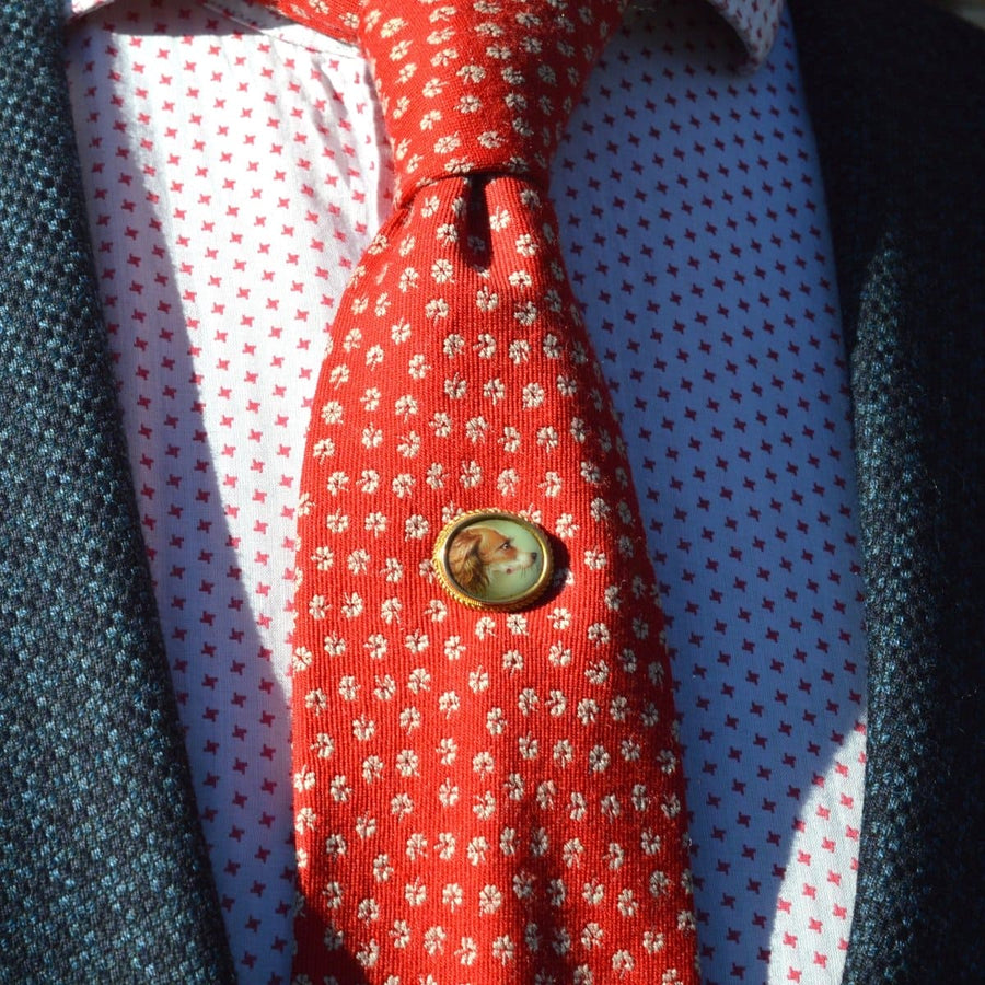 Victorian 18ct gold spaniel dog tie pin on a vibrant patterned silk tie, showcasing exquisite craftsmanship.