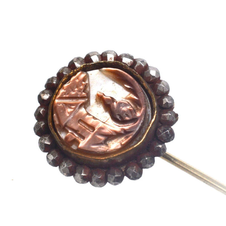 Victorian cut steel tie pin featuring carved brown mother of pearl with a house and lady in 19th century style.